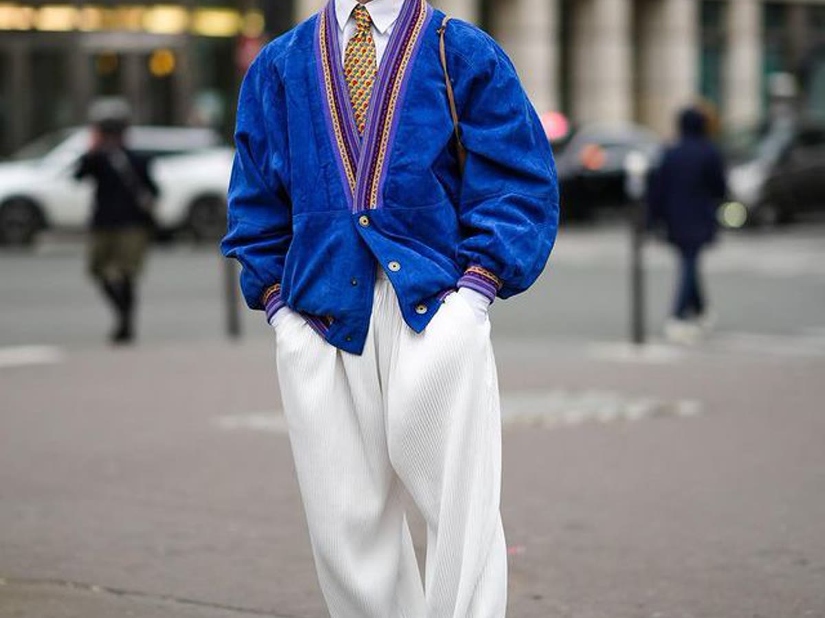 Layered cardigan, tie, and tailored trousers showing a built outfit