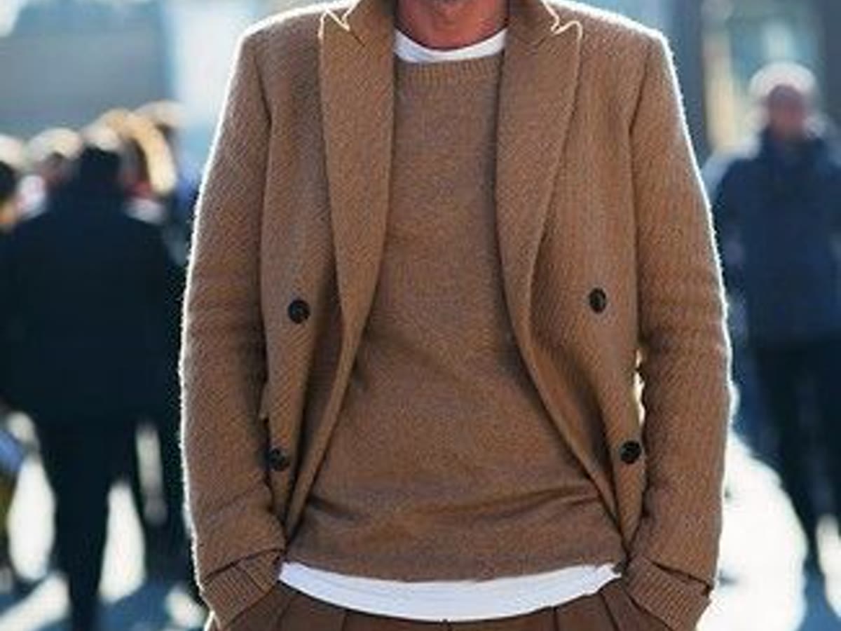 Man in a tan overcoat and layered winter outfit for dressing a heavier belly
